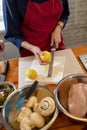 The cook rubs the lemon zest on a grater. Surrounded by ingredients for cooking