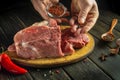 Cook's hand add aromatic spices to raw meat before grilling. Preparing beef meat before roasting Royalty Free Stock Photo