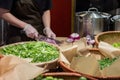 Cook's hands in cellophane gloves cutting red onion into thin slices. Cooking vegetable ingredients Royalty Free Stock Photo