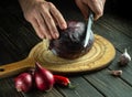 Cook's hands cut with a knife cut red cabbage on a kitchen cutting board. Cooking vegetarian food at home Royalty Free Stock Photo