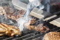 Cook`s hands with a knife check the readiness of the meat steak preparing Royalty Free Stock Photo