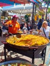 A cook selling Spanish Paella at a gastronomic fair.