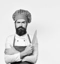 Cook with serious face in burgundy apron and chef hat. Royalty Free Stock Photo