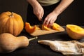 The cook slices the pumpkin for baking.