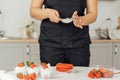 The cook sprinkles flour on a red cake through a sieve Royalty Free Stock Photo