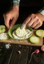 The cook sprinkles sliced marrow with flour before frying. The concept of cooking zucchini on the kitchen table with vegetables