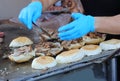 cook in the street food stall preparing a stuffed sandwich with meat and vegetables Royalty Free Stock Photo