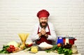 Cook with tricky face in uniform sits by kitchen table