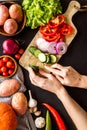 Cook vegetables. Hands cut pepper near autumn harvest on black background top-down Royalty Free Stock Photo