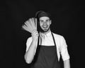 Cook works in kitchen. Chef with smiling face holds bunch of spaghetti Royalty Free Stock Photo