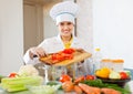 Cook works with tomato and other vegetables Royalty Free Stock Photo