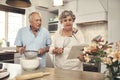 Cookbooks make baking so much easier. a senior couple baking together at home.