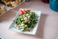 Cooked apetit dish beautifully decorated in a plate on a wooden table, natural light