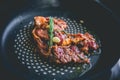 Cooked beef steak with rosemary and garlic inside iron skillet