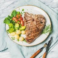 Cooked beef tbone steak with vegetables and rosemary, square crop