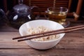 Cooked brown rice in white bowl with chopsticks on the wooden background. Royalty Free Stock Photo