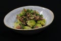 Cooked Brussels sprout with beef bacon in a serving bowl with black background Royalty Free Stock Photo