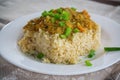 cooked bulgur with meat sauce and vegetables in a plate