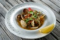 Cooked Clams vongole in a plate. Seasoned with tomatoes and spices.