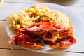 Cooked crab on white plate served with rise and french fries on wooden table, top view.Seafood concept.Selective focus Royalty Free Stock Photo