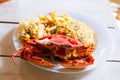 Cooked crab on white plate served with rise and french fries on wooden table, top view.Seafood concept.Selective focus. Royalty Free Stock Photo