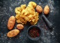 Cooked creamy peppercorn potato chips, snack crisps with sea salt on stone board with marble pestle and mortar. Royalty Free Stock Photo