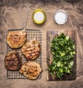 Cooked, delicious grilled pork steak with green salad of cucumber, spinach and arugula wooden rustic background top view close