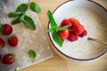 cooked diet oatmeal in a bowl with fresh ripe strawberries