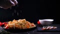 Cooked dish at home in the restaurant the chef decorates the finished pasta dish with grated Parmesan cheese on a kitchen grater