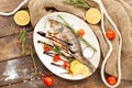 Cooked dorado fish in a plate. On a wooden table.