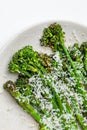 Cooked fresh broccolini with grated cheese and on the plate