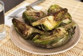 Cooked fried halves artichokes on brown plate Royalty Free Stock Photo