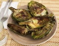 Cooked fried halves artichokes on brown plate Royalty Free Stock Photo