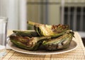Cooked fried halves artichokes on brown plate Royalty Free Stock Photo