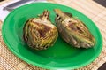 Cooked fried halves artichokes on green plate Royalty Free Stock Photo