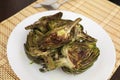 cooked fried halves artichokes on white plate Royalty Free Stock Photo