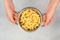 Cooked fusilli pasta in a sieve or strainer, italian food ingredients, hands holding colander Royalty Free Stock Photo