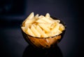 Cooked gluten free pasta penne in glass bowl. Black background