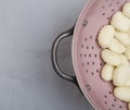 Cooked gnocchi pasta in pink colander