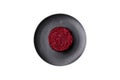 Cooked grated beetroot formed as a cylinder and ready dish on a black plate