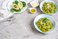 Cooked green spinach tagliatelle pasta on a plate with Parmesan cheese and avocado sauce, Italy food