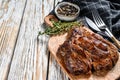 Cooked grilled Chuck eye roll steak on a chopping Board. White background. Top view. Copy space Royalty Free Stock Photo