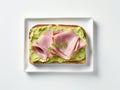 Cooked ham on a rectangular piece of bread spread with avocado purÃ©e Royalty Free Stock Photo