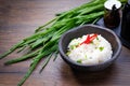 Cooked Jasmine rice in a bowl on wooden table background. Boiled organic Thai Jasmine rice with seasoning and green onion.