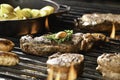 Cooked juicy steak meat beef with garlic and seasoning on top on a flaming grill Royalty Free Stock Photo