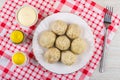 Cooked khinkali in plate, bowl with mayonnaise, shakers with salt and pepper, fork on checkered napkin on wooden table. Top Royalty Free Stock Photo