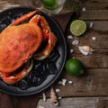 The cooked king crab on black plate with ice. Wooden background. Seafood concept Royalty Free Stock Photo