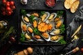 Cooked large green mussels with garlic, parsley and lemon on a metal tray. Seafood. Royalty Free Stock Photo