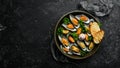 Cooked large green mussels with garlic, parsley and lemon on a metal tray. Seafood. Royalty Free Stock Photo