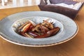 Cooked Lithofaga date shell mussels served on a dish at a wooden table Royalty Free Stock Photo